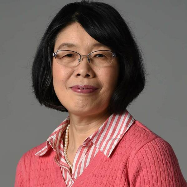 Headshot of Professor Sharon Hu, a woman with short dark hair, glasses, and a coral and white striped shirt.